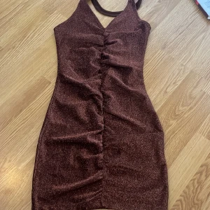 Klänning  - Brun glittrig klänning köpt på hm för ungefär 200kr använd en gång  