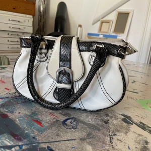 Liten väska - Söt liten miniväska, den är ganska liten men jag kan ändå ha den på axeln. Bra kvalitet på utsidan men missfärgad insida. 