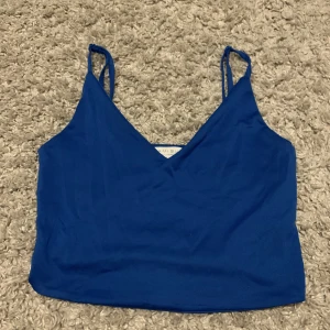 Väldigt fint blått linne!!  - Ett linne i strl S som har justerbara band. Så skulle kunna passa som Xs också🙂köparen står för frakten!!