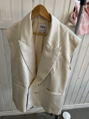 Lång, dubbelknäppt väst från Zara  - Väst. Krage med slag. Dubbelknäppning fram med knappar.   Som ny.  Nypris: 700 
