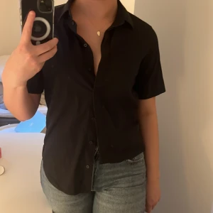 Mörk blå/svart kortärmad skjorta - Köpt på cos i göteborg för nått år sen men aldrig kommit till användning för de inte riktigt är min stil