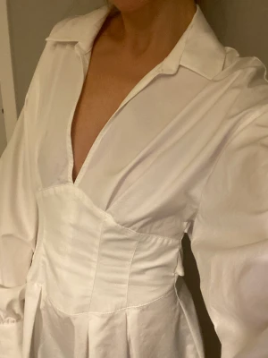 Superfin korsettklänning ❄️ - Köpt här på Plick. Aldrig använd då den var för stor. Är normalt XS och den går halvvägs till knäna på mig som är 166 cm. Superfin i skjortliknande material och med fina detaljer i ryggen. Köpare står för frakt. Hör av dig vid frågor