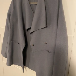 Kappa  - Ljusblå grå kappa från WERA. Aldrig använd i nyskick. 