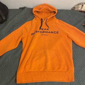 Peak Performance hoodie Orange med svart logo