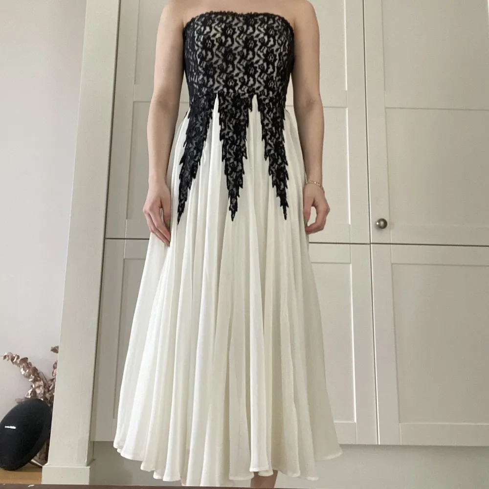 Only worn once, good condition. Really flowy, muted white dress (ankle length). Black lace on the top of the dress. A (well hidden) zipper going down the side of the top of the dress for a good fit. Klänningar.