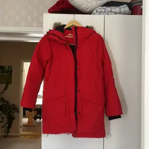 Snygg & varm ny röd Everest vinter jacka.  Har en ficka på insidan samt fyra fickor på utsidan & luva med päls.  Finns både dragkedja & knappar. Storlek 34.