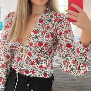 Realisation par topp - Säljer min blommiga realisation par topp i storlek small. 100 % silke. Sitter superfint med knyte i midjan. Sparsamt använd. 