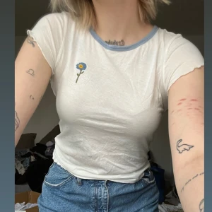 t-shirt med broderad blomma - Så himla gullig t-shirt från &other stories i en off-white färg! Världens skönaste material och en broderad blomma på höger sida. Köptes för runt 4-5 år sedan men sparsamt använ🌻 Skriv för mer info 🫶🏼