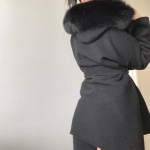 Svart kappa med päls - Kappan är i väldigt nytt skick och har använts några få tal gånger bara. Den är varm men inte för varm. Pälsen är äkta!