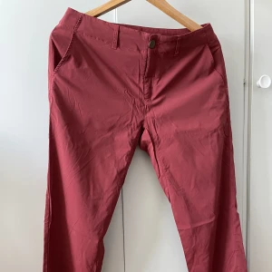 Vinröda Houdini friluftbyxor  - Ett par vinröda friluftsbyxor från Houdini i storlek S.