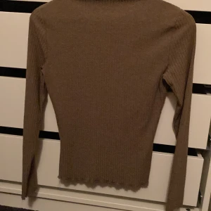 Turtle neck, brun - En ribbad brun långärmad tröja med turtleneck, sitter tight.