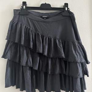 En supersöt DKNY kjol som är mörkgrå och i bra skicka, det ända är att diamanterna åkt av som ni ser på bilden, den är strl S/M