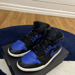 Jordan 1 mid hyper royal - Ett par Jordan 1 mid hyper royal. Köpta på pardon my kicks här i Göteborg. Svensk storlek 44  och storlek 9 i UK och i cm 28. Säljer dem av att de ej passar min klädstil längre  