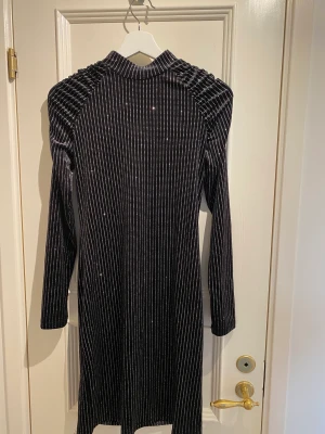 Klänning  - Perfekt långärmad glittrig svart klänning till nyårsafton i sammet/velour. Knappt använd.