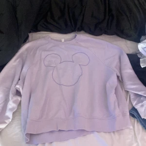 Lila ”hoodie” med mussepigg tecken  - Lila hoodie med mussepigg tecken på oanvänd från h&m