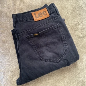 Mörka Lee-jeans - Jeans från Lee köpta 2nd hand. De är raka i modellen och uppklippta längst ner i benen. Lappen säger W33, de passar ungefär en modern W30. 