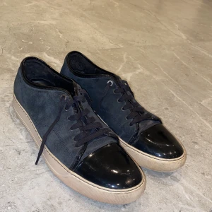 Lanvin skor - Riktigt snygga och populära Lanvin toe cap sneaker. Storlek UK 11 som motsvarar storlek 45. Skicket är 7,5 av 10, inte så jätte använda men finns dock 2 små defekter. Tveka inte att höra av er och ställa några frågor!