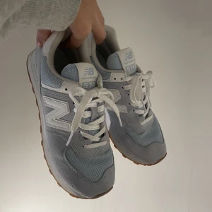 New balance 574 - Ljusblåa new balance 574 i strl 39. Använda några gånger men fortfarande i fint skick. Originalpris ca 800 kr. Köparen står för frakten.