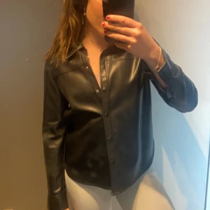 Skinnskjorta - Skinnskjorta från Hm i fake skinn. Köpt för några år sedan men bara hängt i garderoben sedan dess. Storlek 36. 