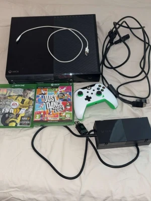 Xbox one 500gb med spel och tillbehör  - Xbox One med vit/grön trådburen handkontroll och två spel, Just Dance 2021 och FIFA 17. Strömkabel och HDMI-kabel syns också på bilderna.