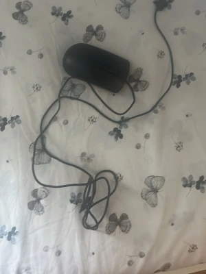 Svart trådbunden datormus DELL - En enkel svart datormus med sladd och två knappar samt scrollhjul. Passar till de flesta datorer med USB-anslutning. Klassisk form och smidig design för vardagsbruk.