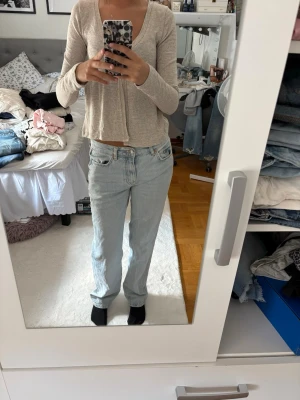 Ljusblå raka jeans med låg midja - Säljer ett par ljusblå jeans med rak passform och låg midja. Jeansen har klassiska fem fickor och en avslappnad look. Perfekta för en chill och trendig stil. Materialet är denim i bomull.