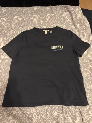 Grå svart Nirvana t-shirt med tryck - Cool grå svart t-shirt med Nirvana-tryck och texten 'Come As You Are' på bröstet. Oversized passform och rund halsringning, perfekt för dig som gillar bandtröjor och vill ha en avslappnad stil. Aldrig använd, bara testad!💕
