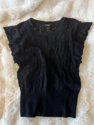 Svart spetsblus med volangärm - Supersöt svart blus från Lindex med spetsdetaljer och volangärmar. 