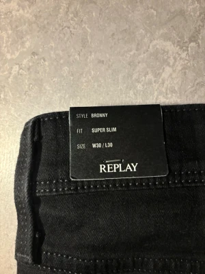 Replay jeans  - Säljer ett par svarta jeans, helt nya med prislapkvar från Replay i comfort denim. Jeansen har klassisk femficksmodell, smal passform och är tillverkade i stretchigt material för extra komfort. Perfekta för dig som gillar en tajt look och stilrena detaljer. Helt ny och köpt från replay butik (nypris 1899), kvitto finns. Bara skriva om de något man undrar