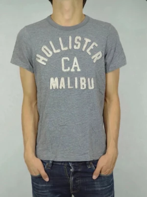Grå Hollister T-shirt-M -  📏 Storlek: M 🎨 Färg:  Grå ✨ Vintage look som ger outfiten en unik känsla 📍 Skick: Fint skick, se bilder!  Frågor? Hör av dig – jag svarar snabbt! 💬 Vid snabb affär kan priset diskuteras 💵 Följare får alltid rabatt 🤝 Skickar inom 24 timmar  
