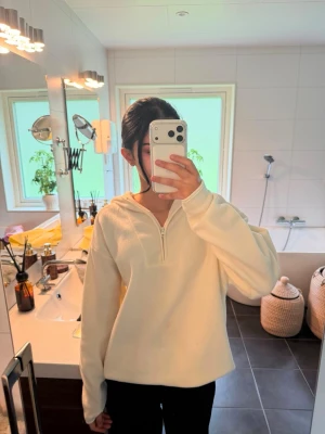 Vit oversized hoodie med halv dragkedja - Snygg vit hoodie i oversized modell med halv dragkedja framtill. Hoodien har långa ärmar och en mjuk, slät yta som ger en clean look. Perfekt för dig som gillar en avslappnad och trendig stil. Helt ny med prislapp🔥