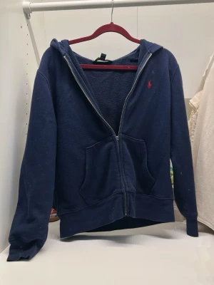 Ralph Lauren hoddie - Fin hoddie från Ralph Lauren, dragkedjan är sönder men den går fortfarande att dra upp som vanligt. Lite vita fläckar. Storlek 10-12, barnstorlek.
