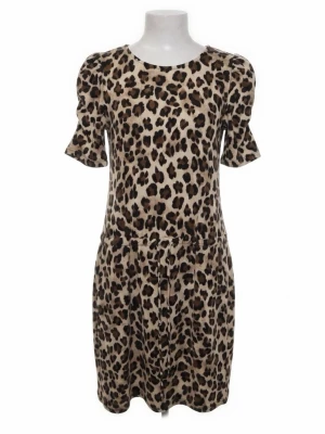 Leopardmönstrad klänning med kort ärm - Snygg leopardmönstrad klänning i beige och bruna toner. Modellen har rund halsringning, korta puffärmar och knytband i midjan för en avslappnad passform. 