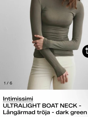 Olivgrön långärmad tröja - Slimmad långärmad tröja från Intimissimi i olivgrönt. Tröjan har en båtringad hals och är tillverkad i ett tunt, mjukt material som sitter tight mot kroppen. Perfekt för lager på lager och enkel att matcha.