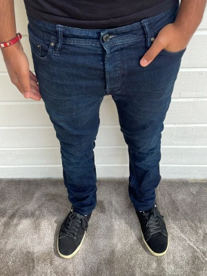 Jack & Jones jeans mörkblå - Hej! Mörkblå Jack & Jones jeans med en Slim-Straight passform. Modellen på bilden är 173cm och väger 74kg. Mycket bra skick på jeansen och inga defekter förekommer. Storlek: W30/L32. 98% bomull 2% elastan. Hör av dig! 🤙 