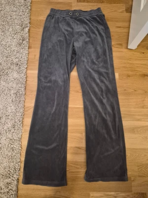Mörkgrå mjukisbyxor Gina Tricot - Mysiga mörkgrå mjukisbyxor från Gina Tricot i mjukt velourmaterial. Byxorna har raka ben, resår i midjan med dragsko och två metallöljetter framtill. Perfekta för chill dagar hemma eller när du vill vara extra bekväm. PRIS KAN DISKUTERAS! Kom gärna med prisförslag och frågor!😊🌸