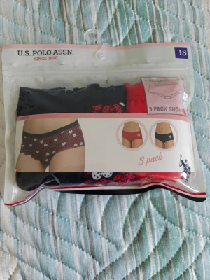 3-pack trosor från U.S. Polo Assn. - Säljer ett 3-pack trosor från U.S. Polo Assn. i storlek 38. Färgerna är svart, röd och mörkblå med söta hjärt- och prickmönster. Trosorna har en klassisk hipster-modell och är tillverkade i stretchigt material för extra komfort. Helt ny/oanvänd! Förpackningen är öppnad, men produkten är i nyskick och har aldrig använts