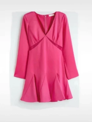 Kort rosa klänning med v-ringning - Säljer en kort rosa klänning med v-ringning och långa ärmar. Klänningen har en figurnära passform upptill och en utsvängd kjol som ger en snygg siluett. Perfekt för dig som vill sticka ut med färg! När under bysten som gör den extra cool.