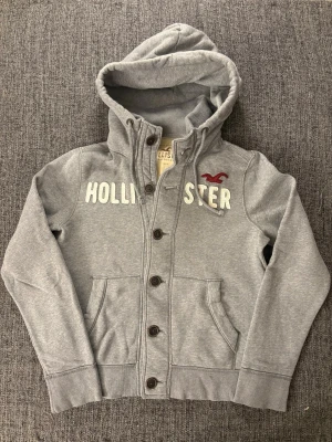 Hollister cardigan | sällsynt  - Sjukt eftertraktad vintage Hollister hoodie i väldigt fint skick (9/10).  Svår att hitta modell med tydlig Y2K-vibe – perfekt för dig som gillar vintage streetwear.  • Mjuk och skön kvalitet   • Bra passform   • Tydlig vintage/Y2K-känsla   • Perfekt för både vardag och layering    📏 Storlek: M   📦 Snabb frakt   💬 Pris kan diskuteras vid smidig affär