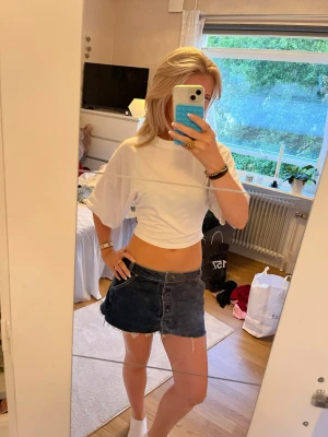 Vit croppad t-shirt med loose fit - Säljer en vit croppad t-shirt med loose passform och korta ärmar. T-shirten har en enkel och clean look, perfekt till jeans eller kjol. Tillverkad i mjuk bomull för skön känsla och avslappnad stil.
