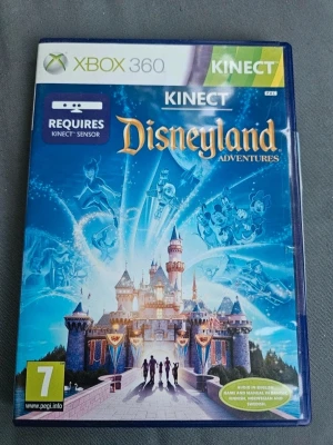 Disneyland Adventures till Xbox 360 - Disneyland Adventures till Xbox 360 Kinect tar dig till magiska Disneyland med klassiska Disney-karaktärer och äventyr. Spelet har ett blått fodral med färgglad omslagsbild av slottet och Disneyfigurer. Kräver Kinect-sensor för att spela.