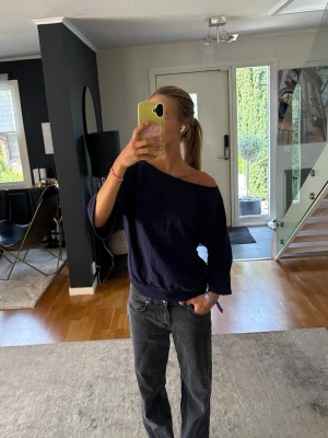 Mörkblå off shoulder tröja - Snygg mörkblå tröja med off shoulder-design och avslappnad passform. Tröjan har trekvartsärmar och är tillverkad i mjuk bomull. 