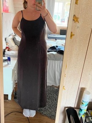 Mörkbrun Laura Ashley klänning med slits - Säljer en mörkbrun långklänning med smala axelband och slits på sidan. 100% silke! 