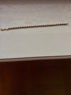 Klassiskt silverfärgat kedjearmband - Stilrent armband i silverfärg med enkel kedjedesign. Perfekt för dig som gillar minimalistiska accessoarer. Lätt att matcha med andra smycken och har ett smidigt lås. Skulle gissa att den är mellan 18-22cm lång. Äkta Silver 925