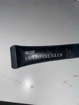 Nailster UV/LED Gel Glue 20ml - UV/LED Gel Glue från Nailster i svart tub, perfekt för att fästa lösnaglar eller dekorationer. Tuben innehåller 20 ml gelélim som härdas med UV- eller LED-lampa. Enkel att applicera och ger starkt fäste för kreativa nageldesigner.köpte den för 200 och säljer den för 60kr!!!