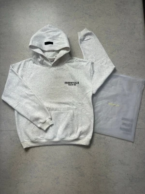 Essential  Fear of God  - Ny Essentials Fear of God hoodie 🤍  Storlek S. Helt ny och i perfekt skick. Väldigt skön och bekväm hoodie med en clean och stilren design. Perfekt för streetwear och passar till nästan allt. Kommer även med originalförpackning enligt bilden.  📏 Size: S ✨ Skick: Ny / perfekt skick 🧥 Modell: Essentials Fear of God 📦 Originalförpackning medföljer