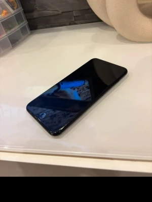 Svart iPhone med rundade kanter - Säljer en svart iPhone med stilren design och rundade kanter. Telefonen har en stor skärm och klassisk hemknapp. Tillverkad i glas och metall, perfekt för dig som gillar Apples enkla och moderna look. Lite repor samt skärmen har lite defekt när man använder den så kan den ibland trycka av sig själv samt att de inte går o trycka på skärmen