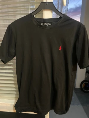 Svart polo t-shirt  - Säljer en svart polo t-shirt med rund hals och korta ärmar. 