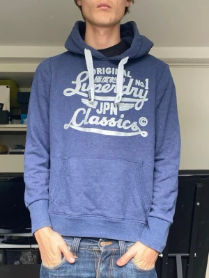Superdry hoodie - En snygg hoodie i blå från superdry i mycket fint skick. Han på bilden är 179, storlek L, sitter som M. Har du några frågor? Fråga på