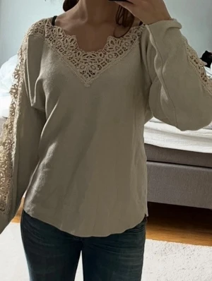 Beige långärmad topp med spetsdetaljer - Beige stickad tröja med spetsdetaljer och v-ringning 